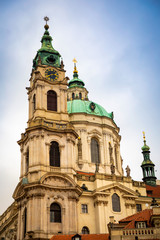 Fototapeta na wymiar Church of Saint Nicolas or kostel svateho Mikulase, view from mostecka street with people in Prague, Czech Republic