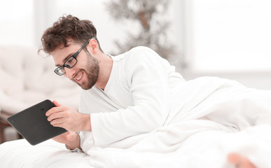 closeup.sleepy man looking at the screen of a digital tablet.