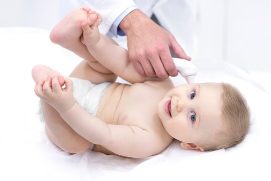 Doctor taking baby's temperature with thermometer