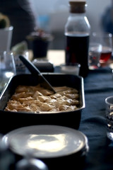 Pan of baklava on a table with coffee and wine. Baklava is traditonal Turkish pastry desset. Selective focus, moody lighting.