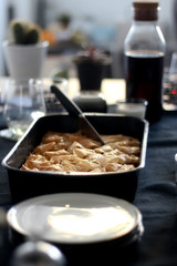 Pan of baklava on a table with coffee and wine. Baklava is traditonal Turkish pastry desset. Selective focus, moody lighting.