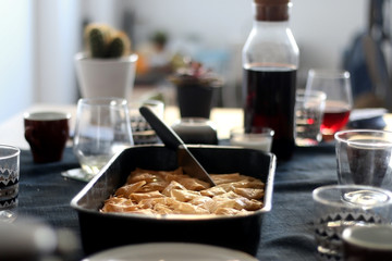 Pan of baklava on a table with coffee and wine. Baklava is traditonal Turkish pastry desset. Selective focus, moody lighting.