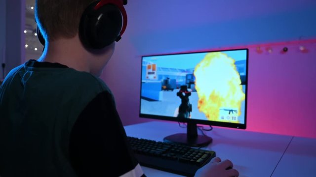 Violent online video game on pc played by a kid wearing a headset