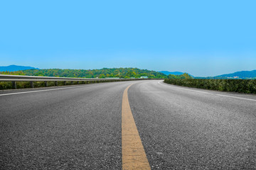 Fototapeta premium Empty asphalt road and natural landscape under the blue sky