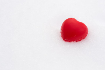 Valentine's day concept. Love composition. Copy space for text. Beautiful red heart on snow background in winter sunny day.