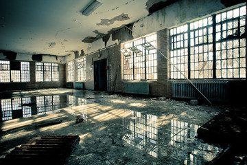 Interior of abandoned mental hospital with broken windows and water flood on floor