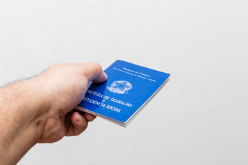 hands of middle-aged man holding work book, Brazilian social security document
