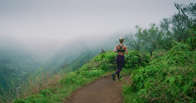 Wide shot of attractive fitness woman on path overlooking gorgeous valley