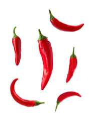 Set with fresh red chili peppers falling against white background