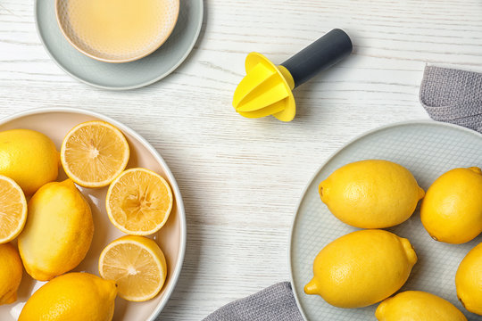 Flat lay composition with reamer and freshly squeezed lemon juice on table