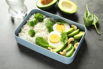 Container with natural healthy lunch on table. High protein food