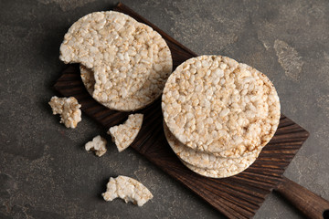 Wooden board with crunchy rice cakes on table