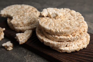Wooden board with crunchy rice cakes on table