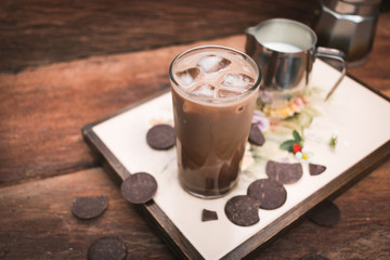 Iced coffee tray with milk and chocolate on wood background