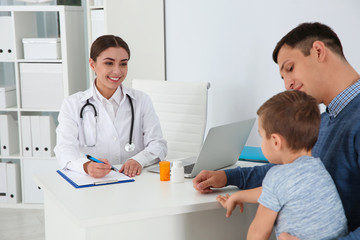 Fototapeta premium Father and son visiting pediatrician. Doctor working with patient in hospital