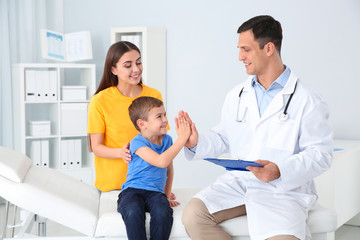 Obraz premium Mother and son visiting pediatrician. Doctor working with patient in hospital