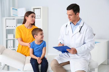 Obraz premium Mother and son visiting pediatrician. Doctor working with patient in hospital