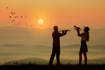 musician play flute and trumpet with sunset or sunrise background