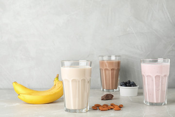 Glasses with different protein shakes and ingredients on table. Space for text © New Africa