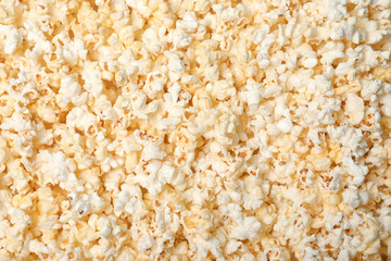 Fresh tasty popcorn as background, top view