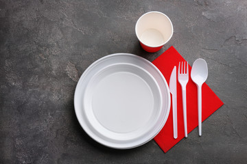 Composition with plastic dishware on grey background, flat lay. Picnic table setting © New Africa
