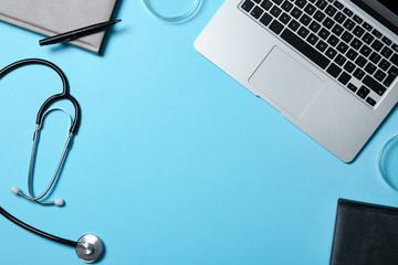 Modern laptop and medical students stuff on color background, top view. Space for text