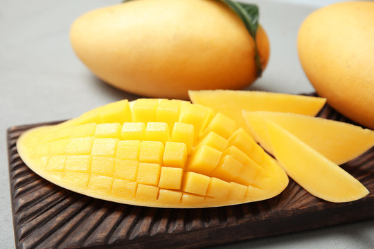 Ripe juicy mango on grey table, closeup