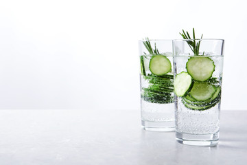 Glasses of fresh cucumber water on table. Space for text