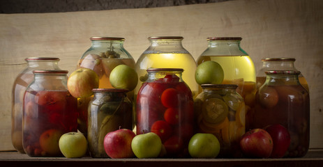 Home-made canned compote and fresh fruit on the basement shelf still life