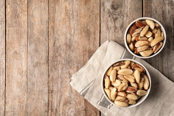 Flat lay composition with Brazil nuts and space for text on wooden background