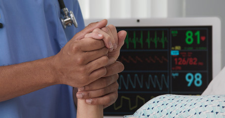 Portrait of registered nurse holding hand of sick patient in hospital bed. Closeup of black nurse...