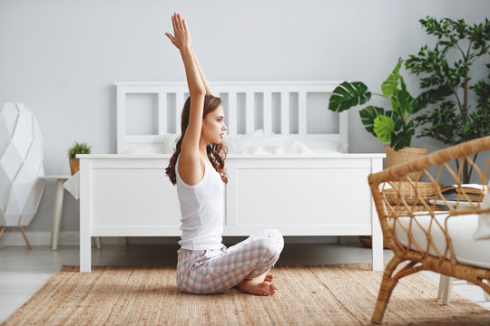 young beautiful girl doing yoga in lotus position at home.