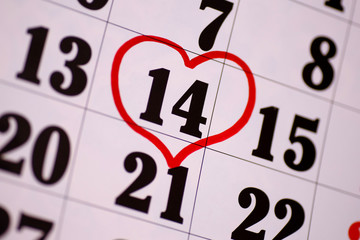 Valentine's Day and the concept of holidays - close-up of a calendar sheet with the date February 14th marked with a red heart-shaped