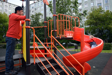 Father and child at a public playground. Russia Moscow.