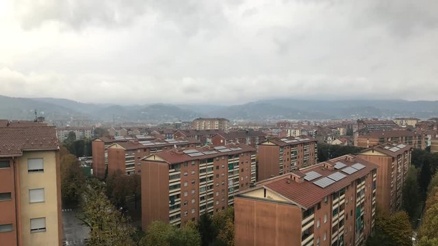 Cinemagraph - Turin, Piedmont, Italy. Gray clouds floating over the housing area on the background of mountains. Barriera di Torino