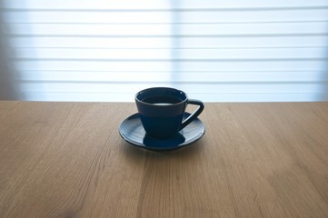 blue cup and coffee on wood table