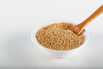 Quinoa grains with spoon and bowl on white background