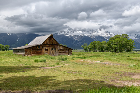 Old mormon barn in Grand Teton Mountains with low clouds. Grand Teton National Park, Wyoming, USA.