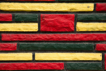 Yellow, green and red peint brick wall