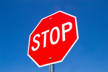 Stop sign with brilliant blue skies in the background.