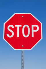 Stop sign with brilliant blue skies in the background.