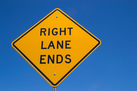 The "Right lane ends" sign with brilliant blue skies in the background.