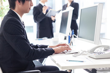 窓際の明るい席でタイピングを行う男性