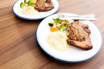 Pork steak with vegetables On the wood background