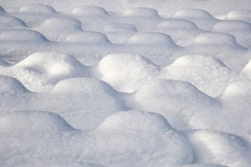 Snow cover in the form of a series of hills.
