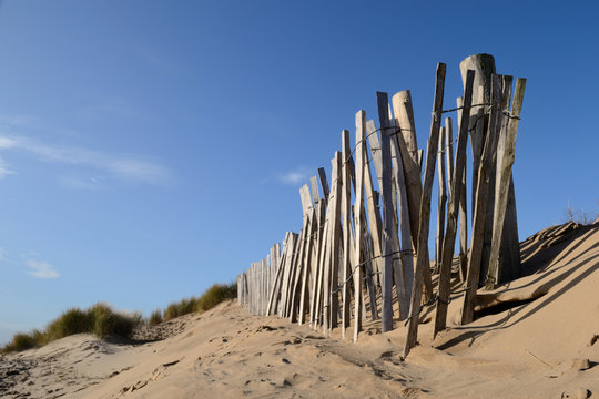 Old wooden fence leading to the sea at Formby Beach, England.