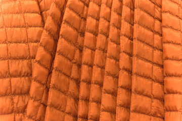 Close-up winter down on clothes rack at American outdoor clothing shop. Insulated fashionable jacket with zip pocket.