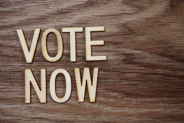 Fototapeta premium vote Now Alphabet Letters on wooden background