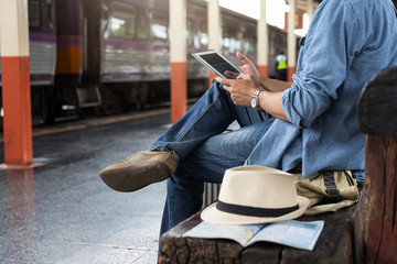 Asian traveler man use tablet to buy train ticket online at train station