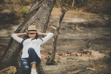 Asian girl sitting under the tree and sleeping.Relax time on holiday concept travel. enjoying time...